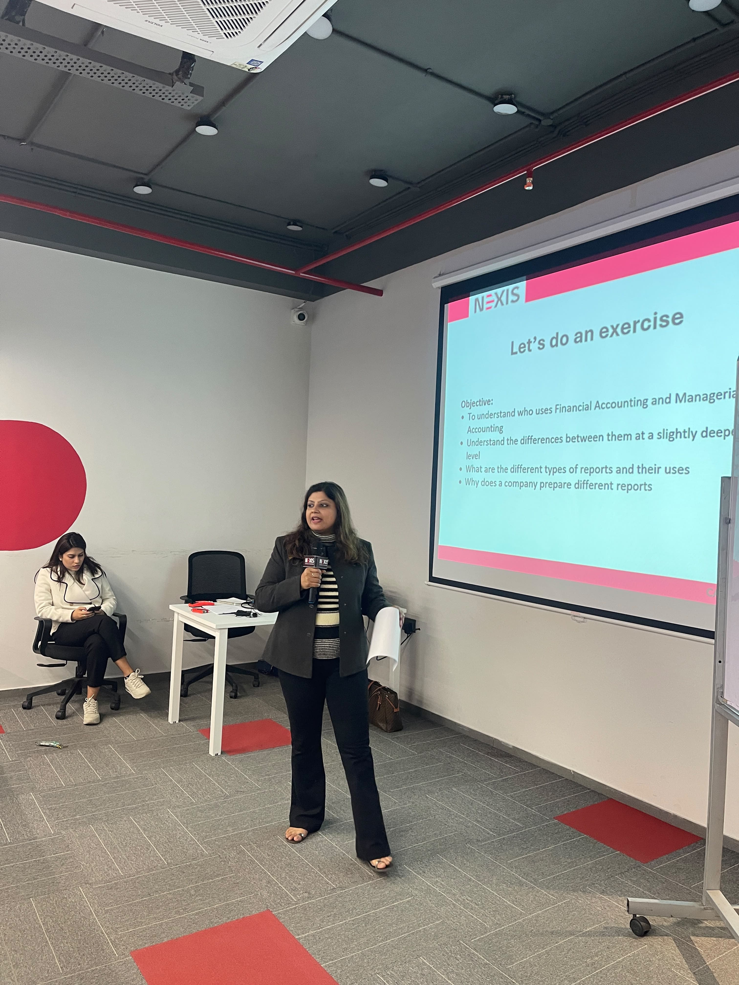 A speaker leading a financial accounting exercise at NEXIS
